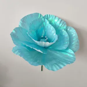 Primer plano de peonía artificial azul iridiscente, perfecta para decoración de escenarios y atrezzo.