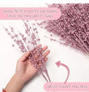 Detail view of shimmering pink glitter berry stems held in hand for holiday decor