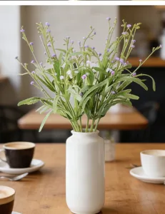 Bouquet de fleurs artificielles gypsophile en vase en céramique blanche déco table.