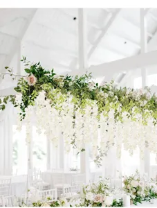 Nahaufnahme weißer künstlicher Blauregenblüten als elegante Event-Dekoration