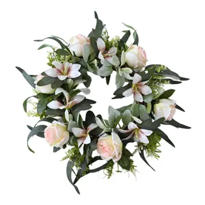 Detailed view of handmade artificial wreath with pink roses, lilies and green leaves
