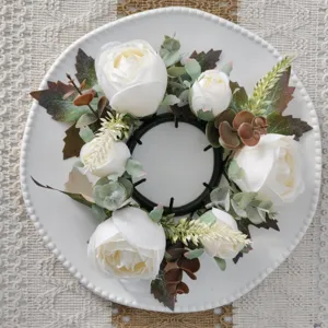 Top view of artificial white rose and maple leaf wreath on a white decorative plate