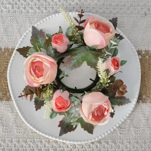 Detailed top view of pink artificial rose and maple leaf candle ring for table decor.