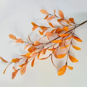 Detailed macro view of artificial autumn eucalyptus leaves with vibrant orange gradient