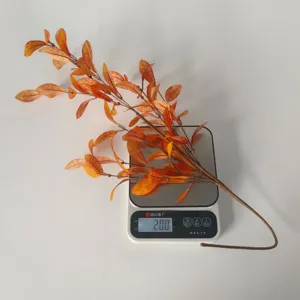 Detailed view of an artificial autumn eucalyptus leaf branch weighing 20g on a digital scale