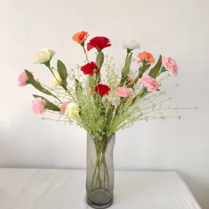 Bouquet d'œillets artificiels multicolores dans un vase en verre gris pour décoration