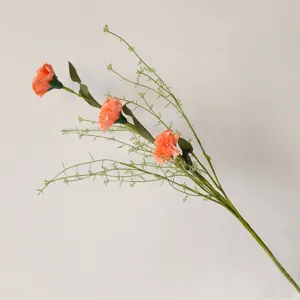 Détail d'un bouquet de trois œillets artificiels corail pour la décoration intérieure