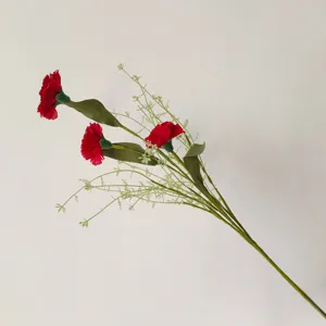 Vue détaillée d'un bouquet d'œillets rouges artificiels avec des feuilles vertes