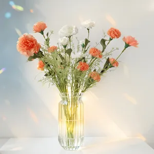 Élégant bouquet d'œillets artificiels dans un vase en verre avec lumière chaude