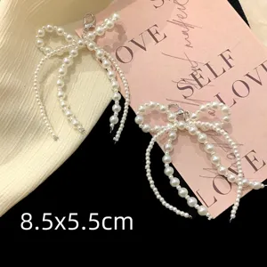 Détail de breloques de chaussures en perles blanches en forme de nœud avec fermoir 8,5x5,5 cm