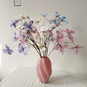 Realistische künstliche Schmetterlingsblumen an Zweigen für elegante Hochzeitsdekoration.