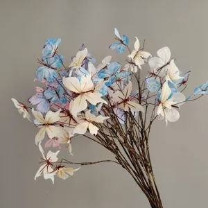 Elegante Kunstzweige mit weißen und hellblauen Schmetterlingsornamenten für Hochzeitsdeko.