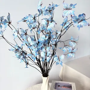 Naturgetreue blaue Schmetterlingsblumen auf dekorativen Zweigen in einer weißen Vase.