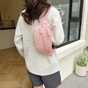 Détail de vue arrière du sac de poitrine en nylon rose, scène de style de vie de voyage.