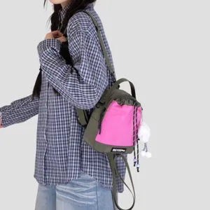 Compact dual-use mini backpack with vibrant pink and green contrast, drawstring and plush charm.