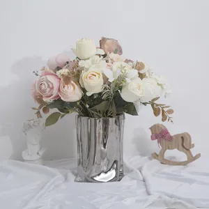 Elegante ramo de rosas y hortensias artificiales en jarrón plateado para decorar