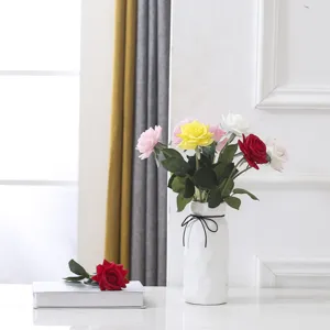 Détail macro de roses artificielles colorées dans un vase décoratif blanc élégant