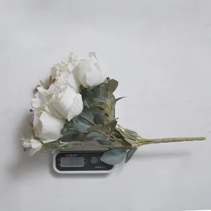Ramo artificial de rosas y hortensias blancas que pesa unos 100 g en una báscula digital