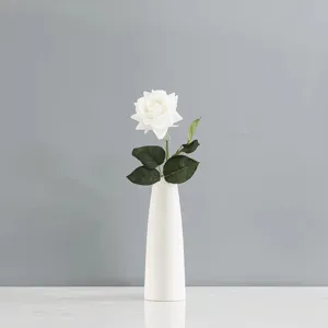 Vue détaillée d'une seule rose artificielle blanche à texture humide réaliste.