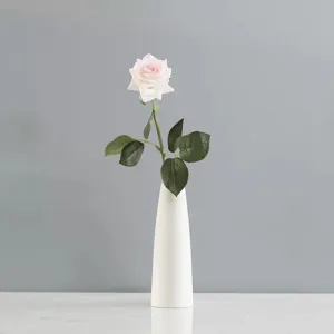 Élégante rose artificielle rose avec texture dans un vase blanc minimaliste