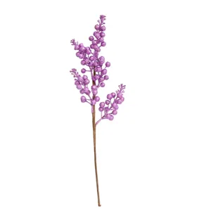 Vista dettagliata di un ramo di bacche finte viola glitterate per decoro natalizio.
