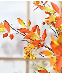 Close-up of artificial Nandina berry branch with autumn orange leaves and berries