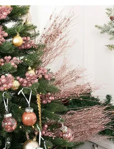 Détail de branches de baies roses scintillantes et ornements sur sapin de Noël