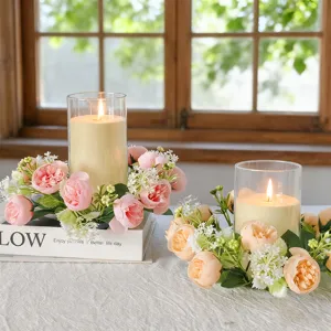 Macro detail of artificial floral candle wreath featuring tea roses and baby's breath