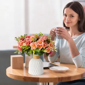 Elegant artificial pink peonies in a white textured vase on a wooden table lifestyle