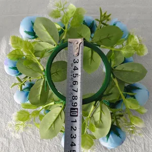 Detailed top view of light blue tea rose candle ring wreath with a measuring tape