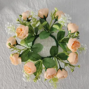 Detailed top-down view of a peach tea rose and white baby's breath floral candle wreath