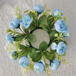 Top-down view of a decorative blue tea rose and baby's breath candle ring wreath