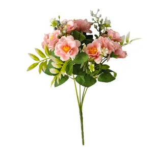 Detail view of pink artificial roses bouquet with green leaves on white background