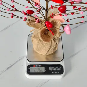 Valentinstag-Herzbaum-Ornament, das auf einer Digitalwaage genau 236 Gramm wiegt