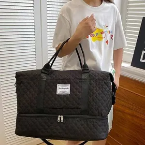 Large black quilted travel duffel bag with bottom shoe compartment for gym and weekend trips.
