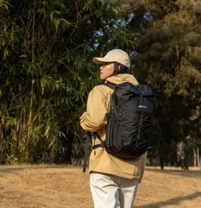 Woman wearing a black waterproof hiking backpack in an outdoor natural forest setting