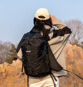 Close-up of a black outdoor hiking backpack being worn in a scenic rocky landscape