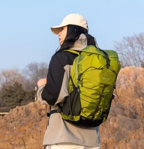 Outdoor lifestyle shot of a large green waterproof hiking backpack on a hiker.