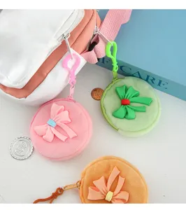 Detailaufnahme von bunten runden Plüsch-Geldbörsen mit süßen Schleifen und Clips