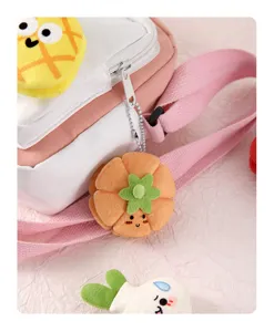 Close-up detail of cute plush bag with fruit vegetable charms, soft material and fine stitching.