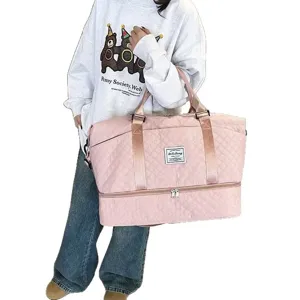 Pink quilted travel duffel bag handheld view, portable gym luggage bag with bottom compartment.