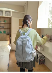 Vista detallada de la mochila estrellada azul claro llevada por una chica en una habitación