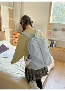 Vista trasera de una mochila azul claro con estampado de estrellas en una habitación acogedre