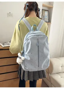 Estudiante que lleva una mochila azul claro con patrón de estrellas y un conejo