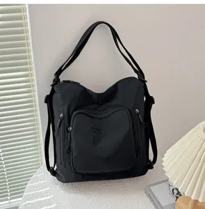 Dettaglio zaino borsa a spalla in nylon nero, design multifunzione con tasche, grande capacità.