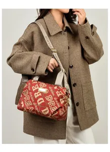 Elegante borsa rossa con stampa a lettere e tracolla indossata da una modella