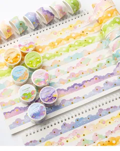 Détail en gros plan du ruban washi Cloud Dreamworld avec étoiles dorées sur carnets.
