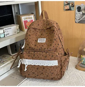 Primer plano de mochila de pana marrón con detalles de encaje y lazos