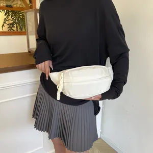 Vue détaillée du sac de poitrine en nylon blanc, mettant en valeur la tirette tressée.