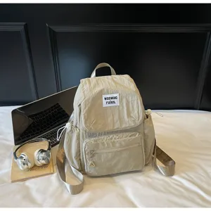 Zaino casual in nylon con tasca frontale e manico superiore per uso quotidiano.